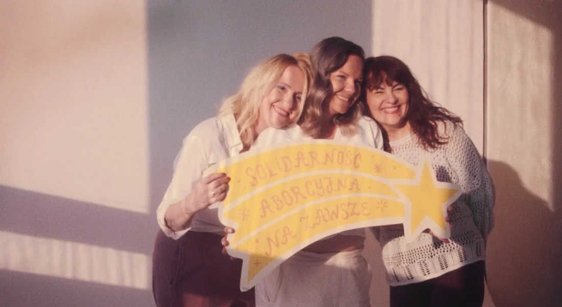 three women with a sign that say abortion is ok